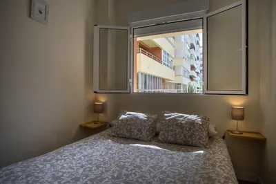 a bedroom with a bed with two pillows and a window at Sirenas Playa Ha Apartment in Cádiz
