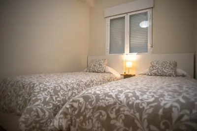 a bedroom with two beds and a window at Sirenas Playa Ha Apartment in Cádiz
