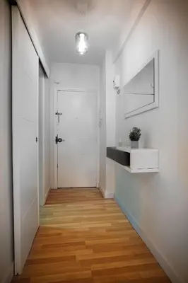 a hallway with a white door and a wooden floor at Sirenas Playa Ha Apartment in Cádiz