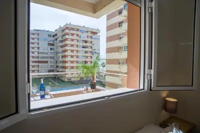a window with a view of a building at Sirenas Playa Ha Apartment in Cádiz