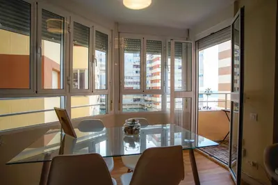 a dining room with a glass table and chairs at Sirenas Playa Ha Apartment in Cádiz