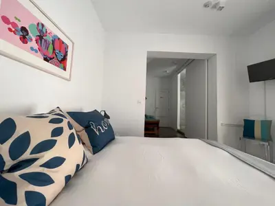 a bedroom with a large white bed with blue pillows at Chipibeach B&B, Hostal Boutique in Chipiona