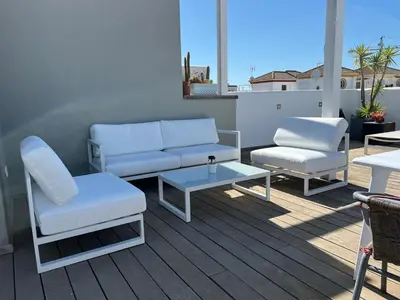 a patio with two chairs and a couch and a table at Chipibeach B&B, Hostal Boutique in Chipiona