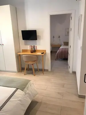 a bedroom with a desk with a computer and a bed at Chipibeach B&B, Hostal Boutique in Chipiona