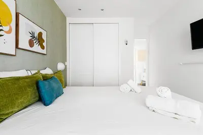 a white room with a bed with towels on it at Casa Brasil - 1ª Linea Playa con Parking Incluido in Cádiz