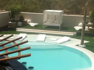 a large swimming pool with a fountain in a backyard at Villa Campito in El Puerto de Santa María