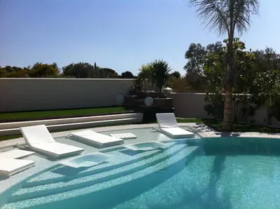 a swimming pool with two lounge chairs and a swimming pool at Villa Campito in El Puerto de Santa María