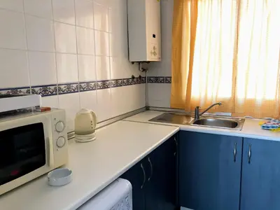 a small kitchen with a sink and a microwave at Apartamento Zinna in Chiclana de la Frontera