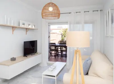 a living room with a couch and a tv at SibsSanlucar Piletas 1ª Linea Playa Piscina Terraza Padel Parking Wifi in Sanlúcar de Barrameda