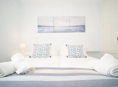 a white bed with towels on top of it at SibsSanlucar Piletas 1ª Linea Playa Piscina Terraza Padel Parking Wifi in Sanlúcar de Barrameda