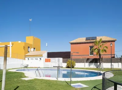 a swimming pool in front of a building at SibsSanlucar Piletas 1ª Linea Playa Piscina Terraza Padel Parking Wifi in Sanlúcar de Barrameda