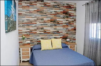 a bedroom with a brick wall behind a bed at Casa Colorado con piscina in Conil de la Frontera
