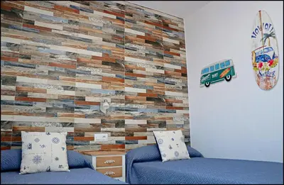 a bedroom with a brick accent wall with a bed at Casa Colorado con piscina in Conil de la Frontera