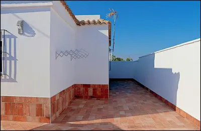 a white wall with a staircase on a house at Casa Colorado con piscina in Conil de la Frontera