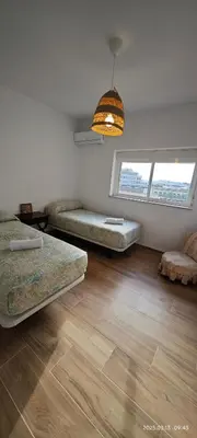 a living room with two beds and a window at JEREZ CENTRO 5 DORMITORIOS TERRAZAS CON VISTAS ALCAZAR Y PLAZA ARENAL in Jerez de la Frontera