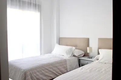 two beds sitting next to each other in a bedroom at City CENTER and Free PARKING apartment in Jerez de la Frontera