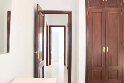 a corridor with wooden doors in a room at City CENTER and Free PARKING apartment in Jerez de la Frontera