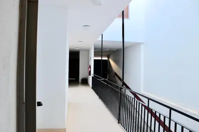 a hallway of a building with white walls and a black railing at City CENTER and Free PARKING apartment in Jerez de la Frontera