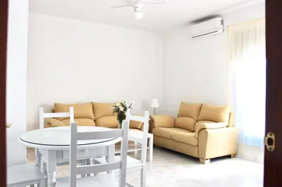 a living room with a couch and a table and chairs at City CENTER and Free PARKING apartment in Jerez de la Frontera