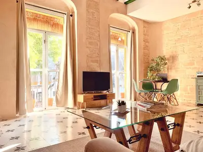 a living room with a table and a television at Feel the Sherry experience1 by Musgo in Jerez de la Frontera