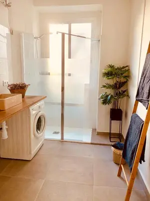 a bathroom with a shower and a washing machine at Feel the Sherry experience1 by Musgo in Jerez de la Frontera