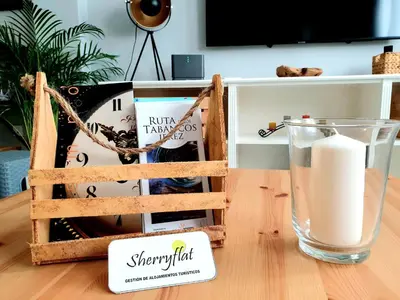 a candle and a glass of milk on a table at Sherryflat Palacio - Parking in Jerez de la Frontera
