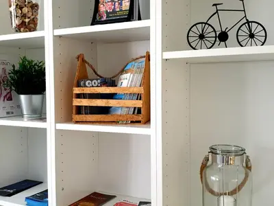 a white book shelf with a bike on it at Sherryflat Palacio - Parking in Jerez de la Frontera
