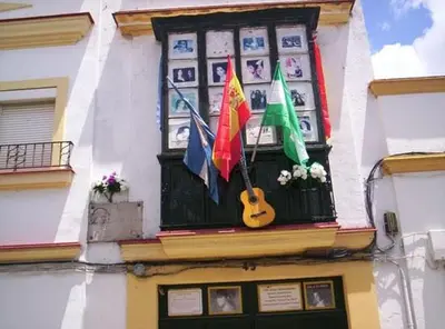 a window with a guitar and flags on a building at Apartamento Centro Sol Plazuela in Jerez de la Frontera