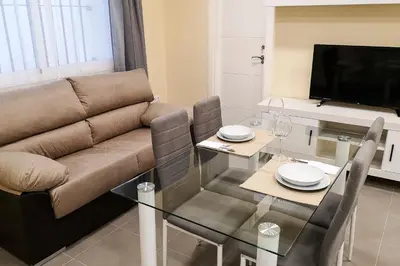 a living room with a couch and a glass table at Apartamentos Jerez Plaza in Jerez de la Frontera