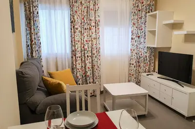 a small living room with a couch and a television at Apartamentos Jerez Plaza in Jerez de la Frontera