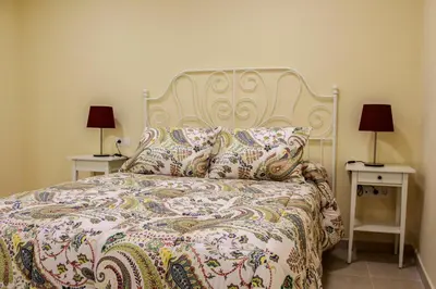 a bedroom with a large bed with two night stands at Apartamentos Jerez Plaza in Jerez de la Frontera