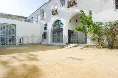 a large white building with a tree in front of it at Loft24Sanlúcar in Sanlúcar de Barrameda
