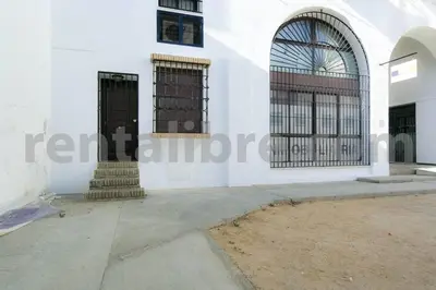 a white building with black gates on the side at Loft24Sanlúcar in Sanlúcar de Barrameda