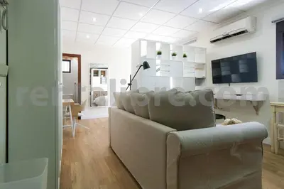 a living room with a couch and a tv at Loft24Sanlúcar in Sanlúcar de Barrameda
