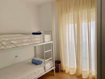 a small bedroom with a bunk bed and a window at Puerta de Santa Maria Grupo AC Gestion in Cádiz