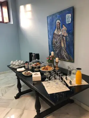a table with food and a painting on the wall at Hotel Boutique Convento Cádiz in Cádiz