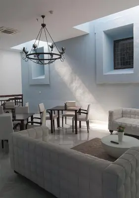 a living room with a couch and a table and chairs at Hotel Boutique Convento Cádiz in Cádiz