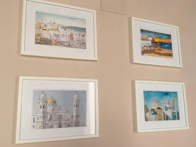 four framed drawings of buildings on a wall at La Viña (centro histórico) in Cádiz