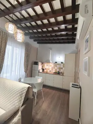 a room with a bed and a table and a kitchen at La Viña (centro histórico) in Cádiz