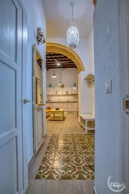 a hallway with a door and a room with a table at CASA ARCO DEL CAÑÓN - Casita con Encanto in Medina Sidonia