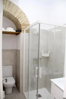 a bathroom with a glass shower with a toilet at CASA ARCO DEL CAÑÓN - Casita con Encanto in Medina Sidonia