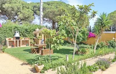 a garden with a picnic table and trees at Chalet Pilahito in Conil de la Frontera