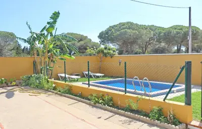 a fence around a swimming pool in a yard at Chalet Pilahito in Conil de la Frontera