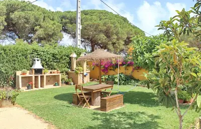 a garden with a picnic table and a grill at Chalet Pilahito in Conil de la Frontera