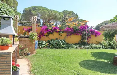 a garden with flowers hanging on a fence at Chalet Pilahito in Conil de la Frontera