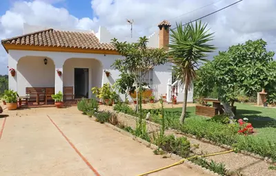 a small white house with a garden at Chalet Pilahito in Conil de la Frontera