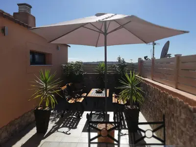 a patio with a table and an umbrella at Apartamento Jerez Terraza Privada in Jerez de la Frontera
