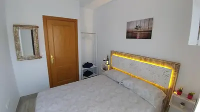 a bedroom with a bed with a yellow head board at Apartamento Jerez Terraza Privada in Jerez de la Frontera