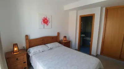 a bedroom with a bed and two lamps and a bathroom at Apartamento Jerez Terraza Privada in Jerez de la Frontera