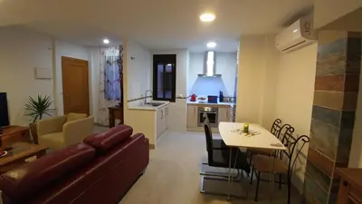 a living room and kitchen with a couch and a table at Apartamento Jerez Terraza Privada in Jerez de la Frontera